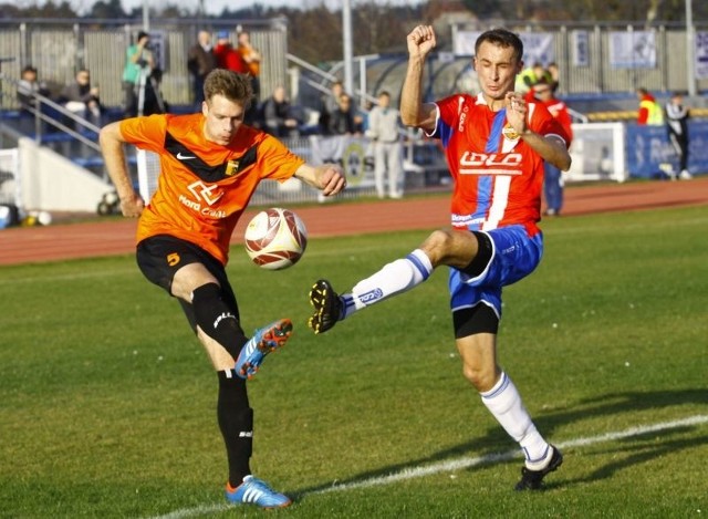 Obrońca Chemika Łukasz Jaciuk (z prawej) próbuje zatrzymać piłkę po dośrodkowaniu pomocnika zespołu z Ozimka Błażeja Gajosa.