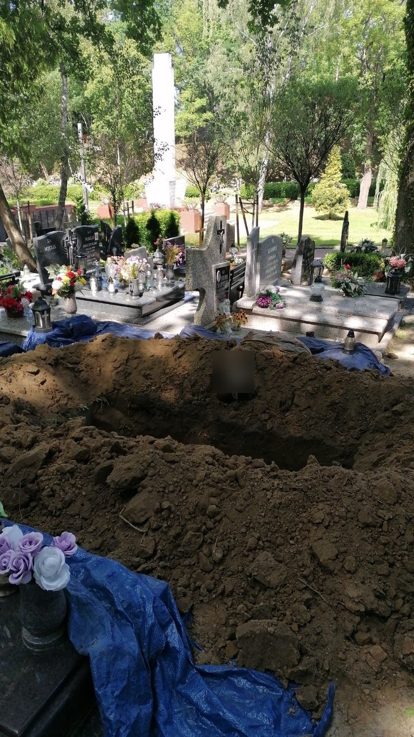 Ludzkie szczątki (zapikslowane) leżące obok grobu.