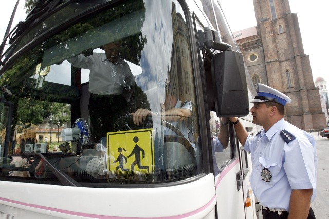 Policjanci sprawdzają autokary przed wyjazdem dzieci na wycieczki.