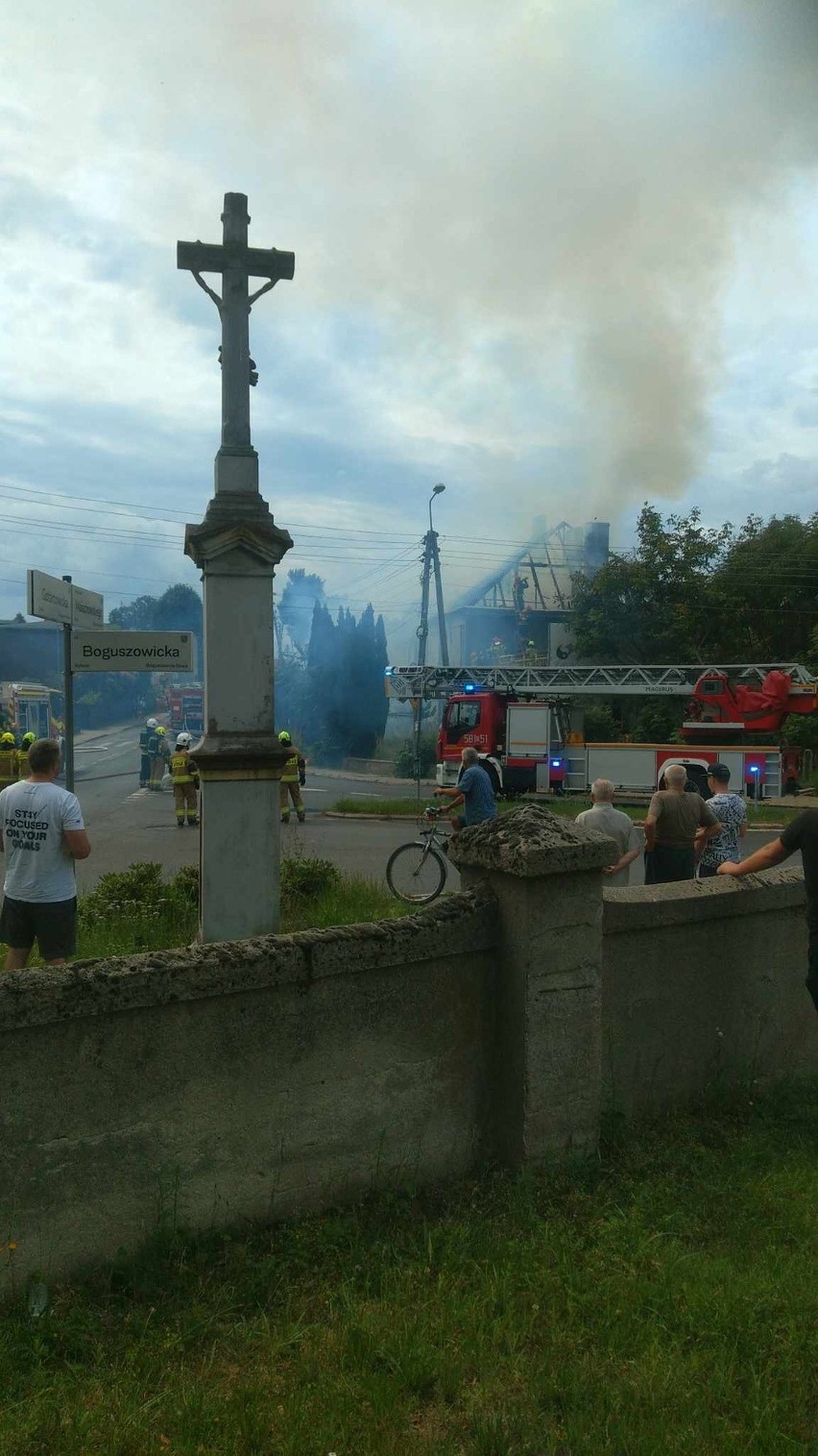 Strażacy walczą z ogniem, który objął dach budynku