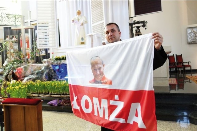 Uczestnicy pielgrzymki z parafii pw. Krzyża Św. pojechali do Rzymu z taką flagą i w koszulkach z logo Łomży. Na zdj. ks. Dariusz Niewiński, duszpasterz pielgrzymki na dzień przed wyjazdem.