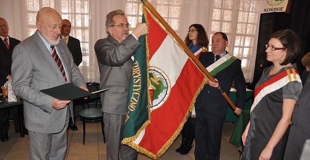 Sekretarz generalny PTTK Andrzej Gordon dekoruje sztandar koneckiego oddziału PTTK Złotą Honorową Odznaką PTTK