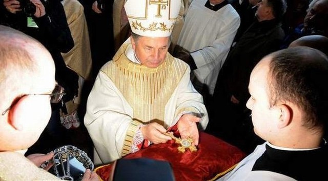Biskup Henryk Tomasik odbiera krzyże i klucze na progu radomskiej katedry od jej proboszcza księdza Edwarda Poniewierskiego.