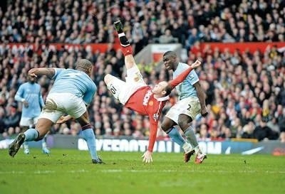 Wayne Rooney (MU) strzela gola. Z prawej Micah Richards, z lewej Vincent Kompany (obaj MC) Fot. PAP/EPA/Robin Parker