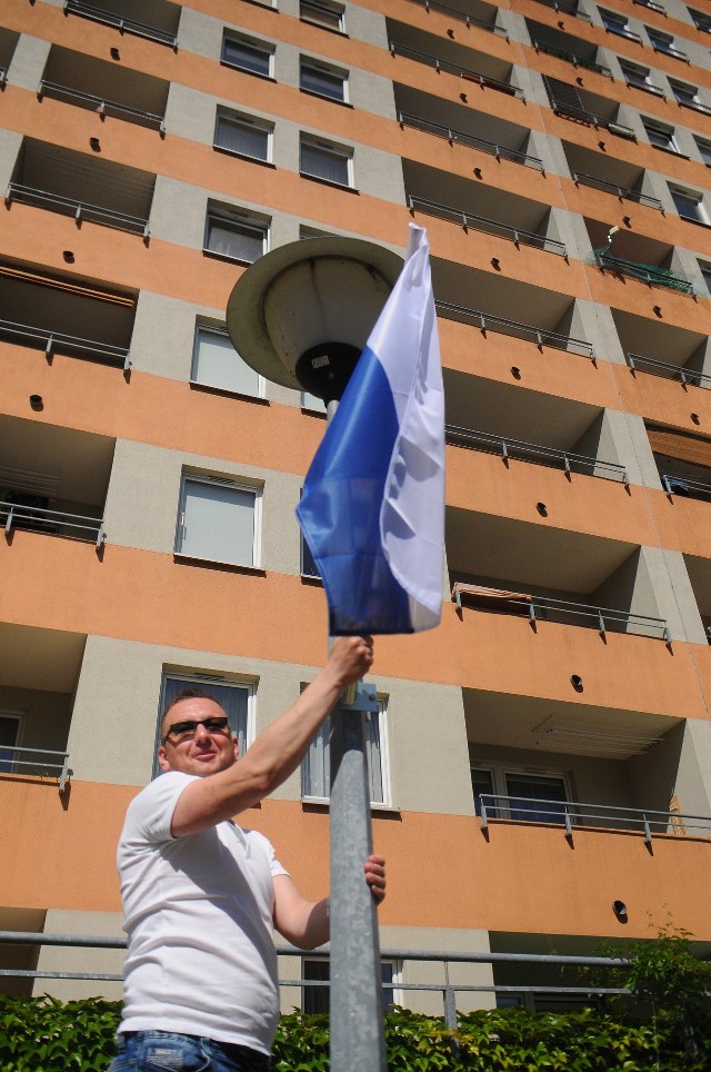 Z okazji nowego święta biało-błękitne flagi na osiedlu Oświecenia zawiesza m.in. Sebastian Kwiatkowski