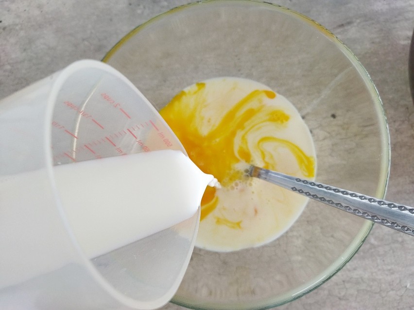 Do jednej z misek wbij jajka i wlej mleko.