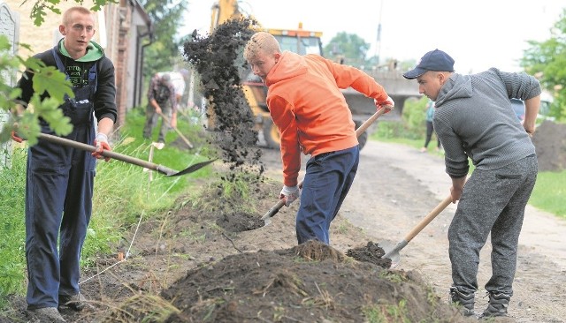 Robotnicy równają ziemię, by mogli równo postawić krawężniki. A potem położyć kostkę brukową.