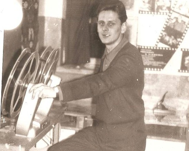 Jan Stypiński w kabinie kinooperatora przy przewijarce taśmy filmowej. Zdjęcie wykonano w latach 70.