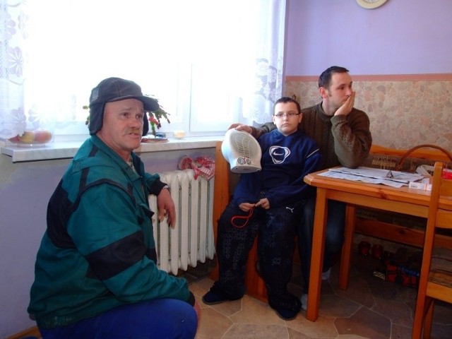 - Musimy ogrzewać mieszkanie grzejnikiem elektrycznym - żali się  pan Zygmunt (na zdjęciu z synami Michałem i Romanem).