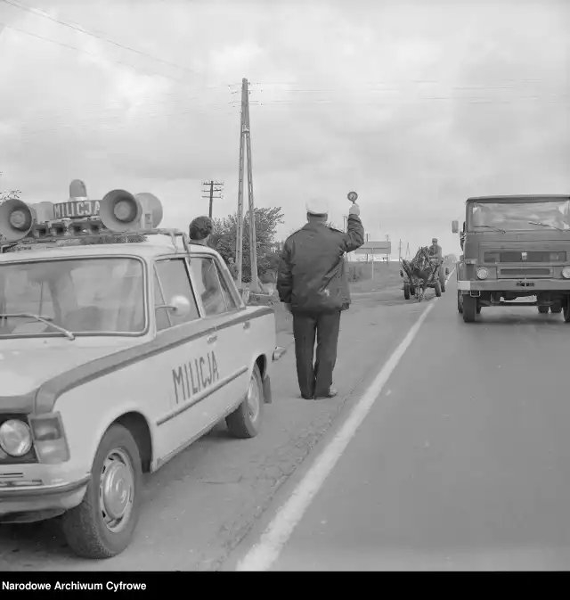 Kontrole drogówki w latach 70. Na zdjęciu: Milicjant przy radiowozie Fiat 125p zatrzymuje furmankę. Na jezdni ciężarówka "Star"