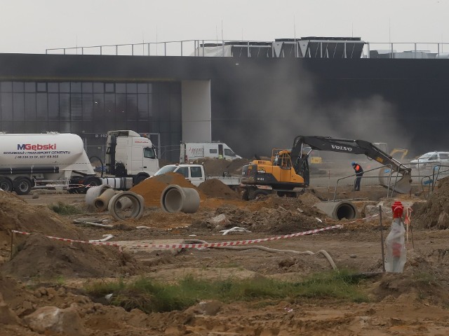 Duże postępy na budowie Portu Lotniczego Warszawa – Radom. Zgodnie z zaplanowanymi harmonogramami trwają prace w niemal wszystkich częściach lotniska. W terminalu odbywają się prace wykończeniowe, a także związane z instalacją urządzeń lotniskowych. Trwa budowa obiektów towarzyszących, czyli magazynów oraz budynku który będzie służył Straży Granicznej oraz celnikom. Budowane są też płyty postojowe po dwóch stronach terminala oraz drogi kołowania - zarówno we wschodniej jak i zachodniej części lotniska. Widać już niemal w stanie surowym wieżę kontroli lotów i strażnicę lotniskowej straży pożarnej. Trwa też budowa wewnętrznych dróg technicznych na lotnisku. Na kolejnych slajdach zobacz jak wyglądała budowa lotniska we wtorek 12 października.Używaj gestów i strzałek.