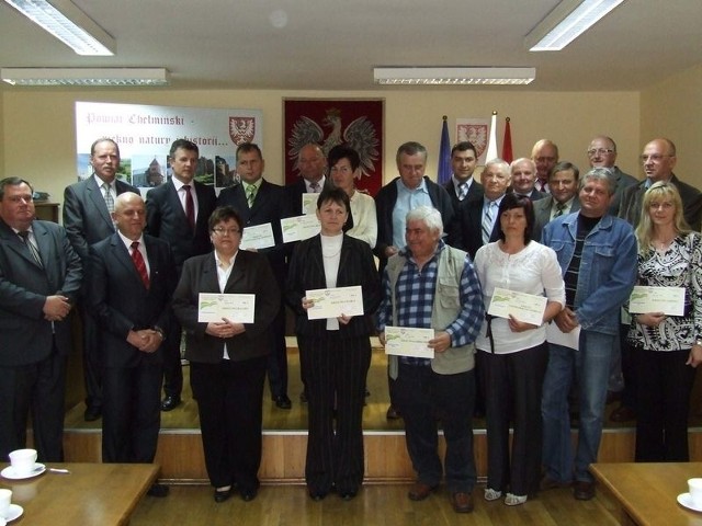 Nagrodzeni sołtysi dumnie prezentują czeki. Obok - organizatorzy konkursu, wójtowie i członkowie Zarządu Powiatu