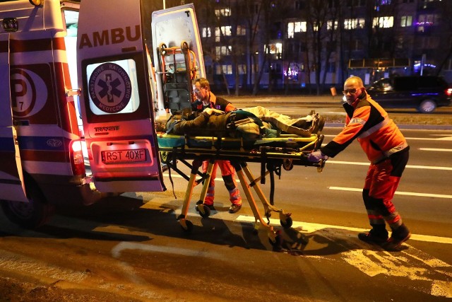 Ratownicy medyczni zabierają do karetki pogotowia ratunkowego dziewczynę potrąconą na przejściu dla pieszych