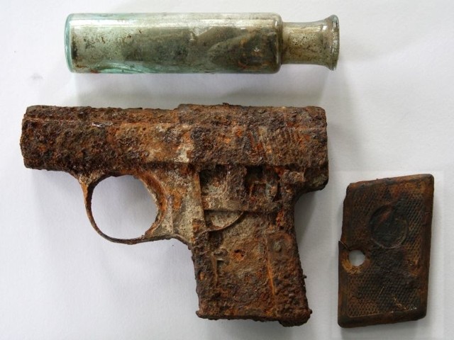 Broń i 6 nabojów w szklanej fiolce została wykopana przez pracowników zakładu podczas prac związanych z termomodernizacją jednej z kamienic przy ul. Rynek 23