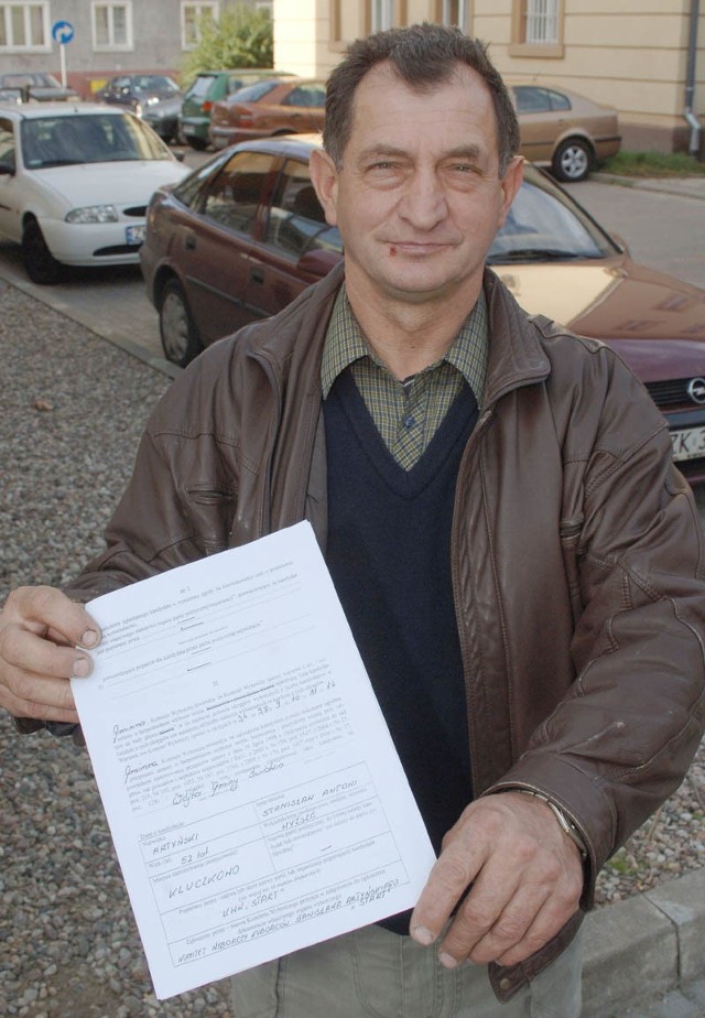 Stanisław Artyński pokazuje protokół komisji wyborczej o zarejestrowaniu go jako kandydata na wójta gminy Świdwin.