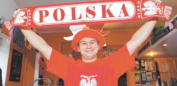 Michał Lisiewicz ze sklepu sportowego Rekord w Koszalinie prezentuje gadżety, które są obowiązkowe dla każdego szanującego się kibica.