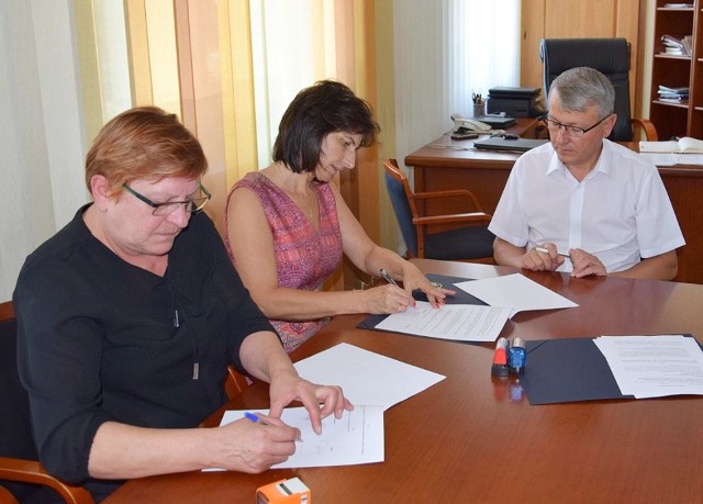 Umowę podpisują: Wanda Węgrzyn( z lewej) i Agata Binkowska. W tle wójt Mirosław Seweryn