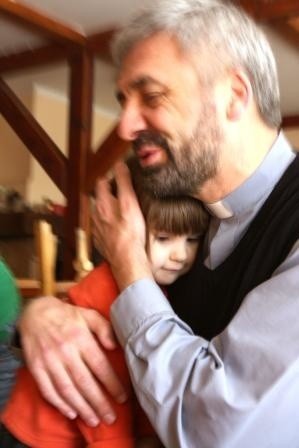 Ojciec Konkol przytula trzyletnią Olę. Podobnie jak tysiące innych, dziewczynka czeka na świąteczne paczki.