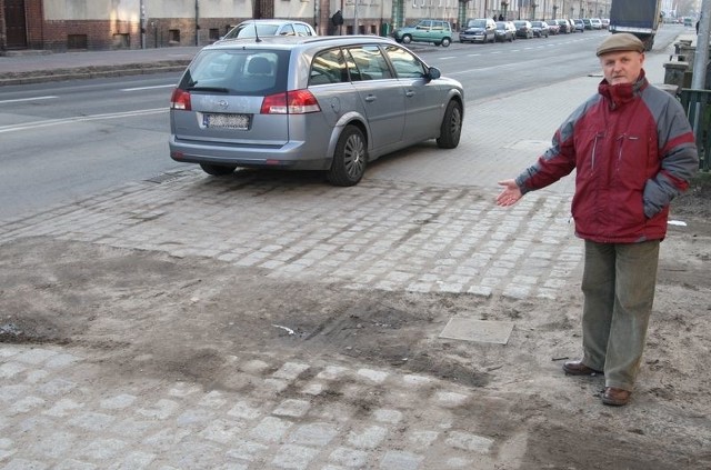 Pan Jan przy zniszczonym podjeździe na swoje podwórko.