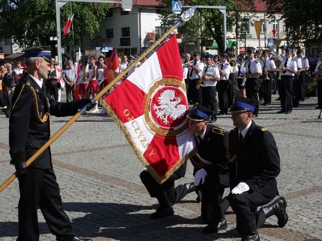 Komendant Ryszard Sieńko przekazuje sztandar strażakom.