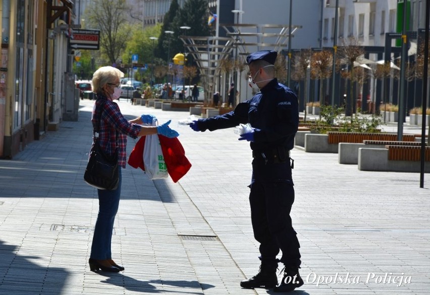 Opolscy policjanci rozdają maseczki na ulicach miasta.
