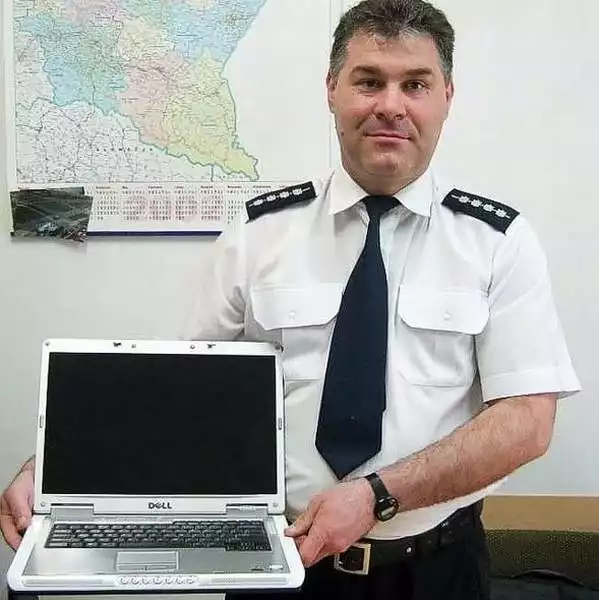 Andrzej Walczyna prezentuje odzyskanego przez policję laptopa .