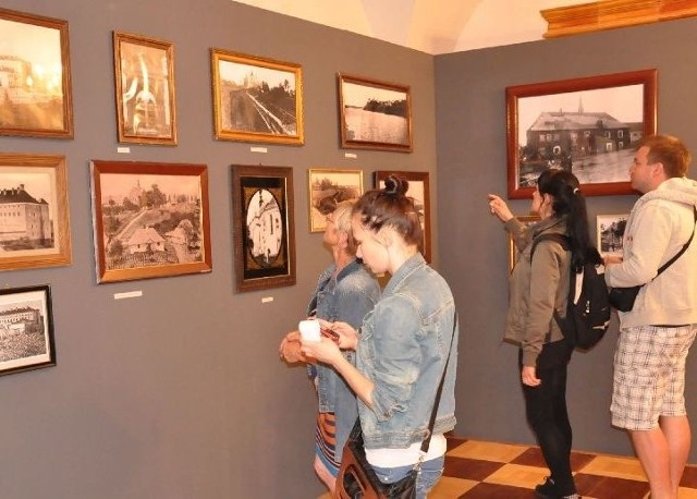 Wiele osób oglądało wystawę pokazującą stary Sandomierz w fotografii.