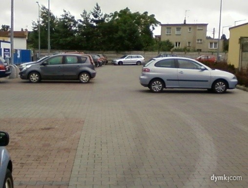 Kierowca auta po prawej zaparkował na środku drogi na parkingu w Sulechowie.