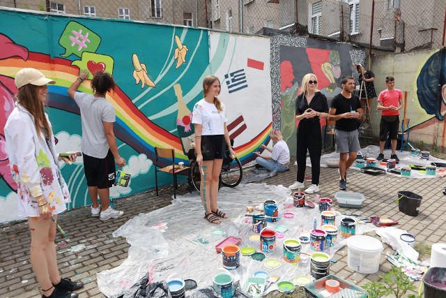 Młodzi artyści podczas tworzenia murali na ścianie ogrodzenia boiska Szkoły Podstawowej nr 26 w Łodzi.