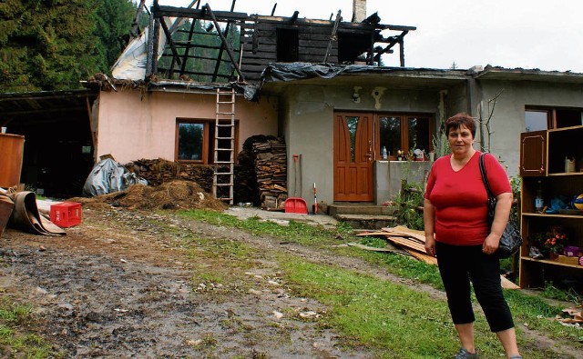 Anna Bachleda stoi przed pogorzeliskiem. Na zdjęciu widać, że ogień zniszczył całe drewniane piętro, gdzie było kilka pokoi. Z boku leży parę rzeczy, które zdołano wynieść z płonącego obejścia