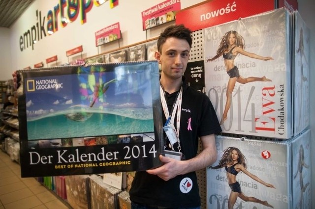 Jakub Paszkiewicz prezentuje kalendarze na 2014 rok.