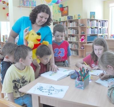 Bibliotekarka Iwona Dziuda potrafi zainteresować dzieci książkami i kolorowankami 