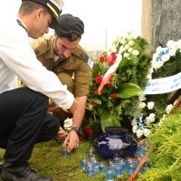 Żołnierze zapalili świeczki i położyli kamyki na pomniku