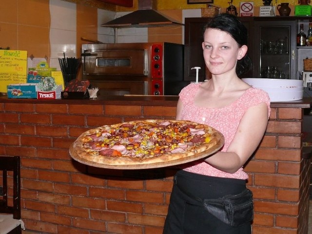 Kelnerka Karolina Piłat prezentuje flagowy produkt - pizzę Boss z pizzerii Na Maxa przy ulicy 11 listopada w Ostrowcu.