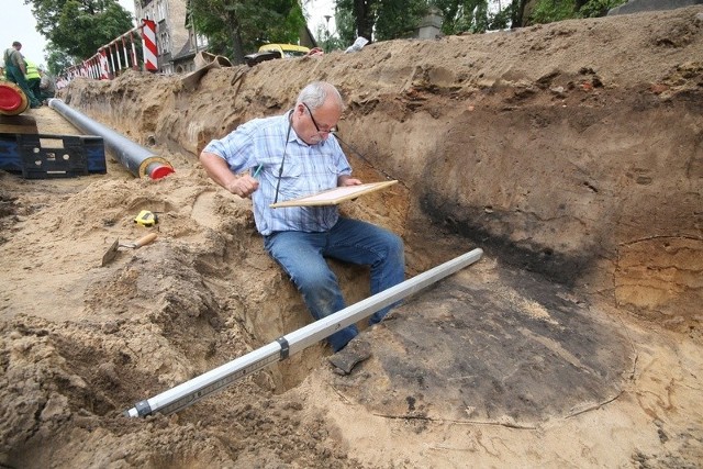 Archeolog Stanisław Sinkowski dokumentuje znalezisko