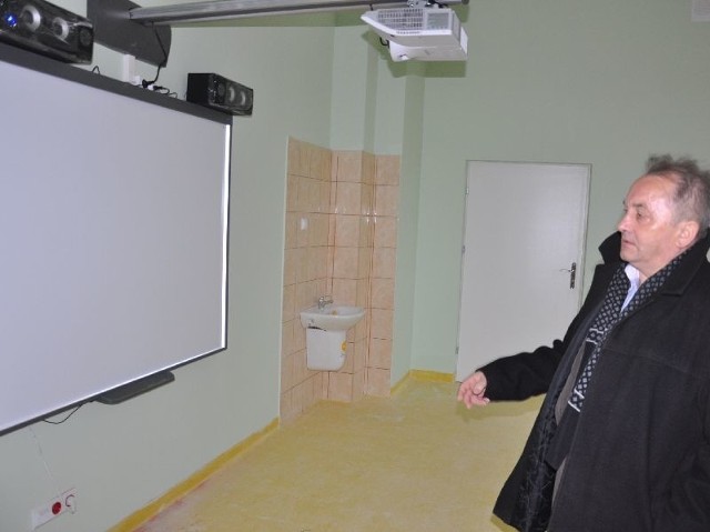 Szkoła będzie wyposażona w tablice interaktywne. Jedna jest już zamontowana. Pokazuje ją dyrektor Sławomir Mazurek.