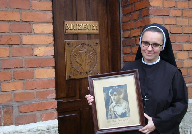 Siostra Urszula przed muzeum w klasztorze Sióstr Serafitek w Oświęcimiu pokazuje zdjęcie siostry Eligii Leopoldyny Staweckiej w mundurze wojskowym