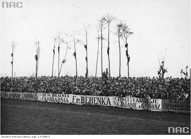 Mecz piłki nożnej Wisła Kraków - Cracovia w Krakowie (1938)Tłumy kibiców zgromadzone przed meczem i "zielone trybuny" (kibice) na drzewach. Na ogrodzeniu stadionu widoczna reklama: "Chemiczna pralnia i farbiarnia Fr. Będenka. Czyści i farbuje na żądanie w 6 godzin".