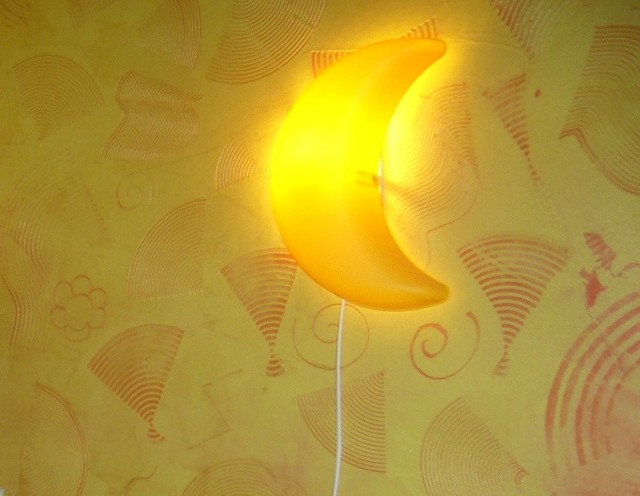 Dyżurny księżyc jako oświetlenie dekoracyjne w pokoju dzieckaOświetlenie dekoracyjne w pokoju dziecka bardzo często pomaga zasnąć dziecku, które boi się ciemności.