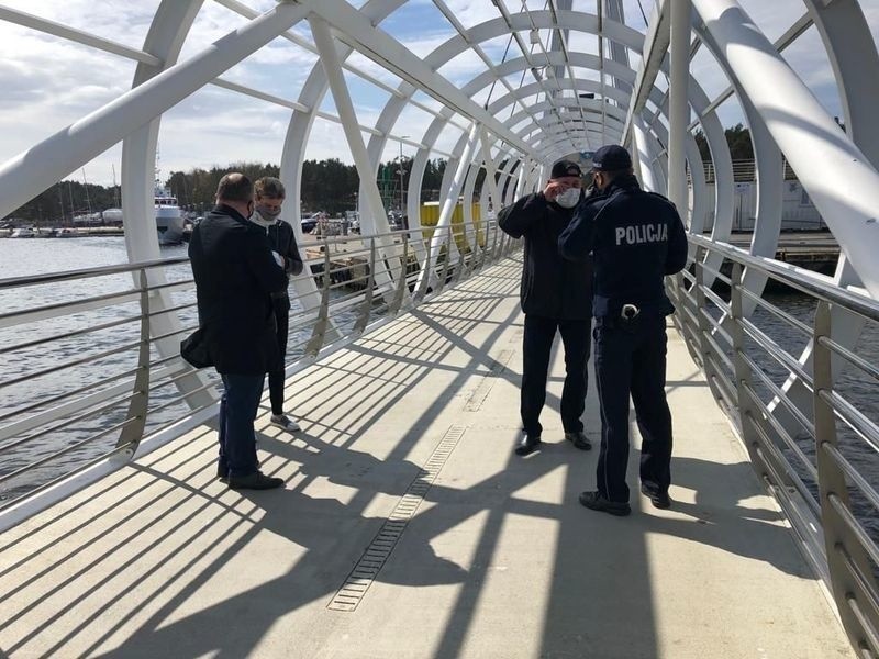 Policjanci i pracownicy starostwa rozdawali maseczki spacerowiczom na usteckiej promenadzie