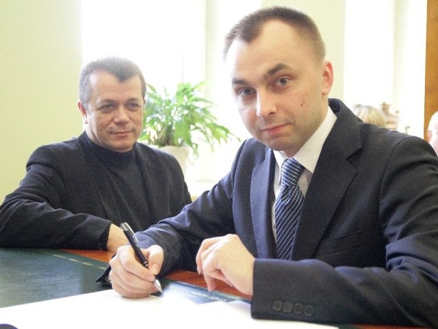 Adam Dębski składa podpis, obok Krzysztof Paliński, dyrektor zarządzający Oddziału Mediów Regionalnych w Białymstoku, wydawcy "Kuriera Porannego"