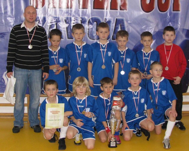 Młodzi piłkarze ze swoim trenerem Grzegorzem Rausem tuż po otrzymaniu medali.