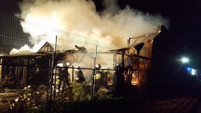 Strażacy gasili pożar, który wybuchł we wtorek (25 października) po godzinie 19.00 w Antoniowie w gminie Ozimek. Zostali wezwani do pożaru samochodu. Na miejscu okazało się, że płoną dwa drewniane budynki gospodarcze. Teraz zastępy  bronią przed ogniem dwa inne, sąsiadujące obiekty. Akcja może potrwać kilka godzin. Nie wiadomo, co było przyczyną pożaru.