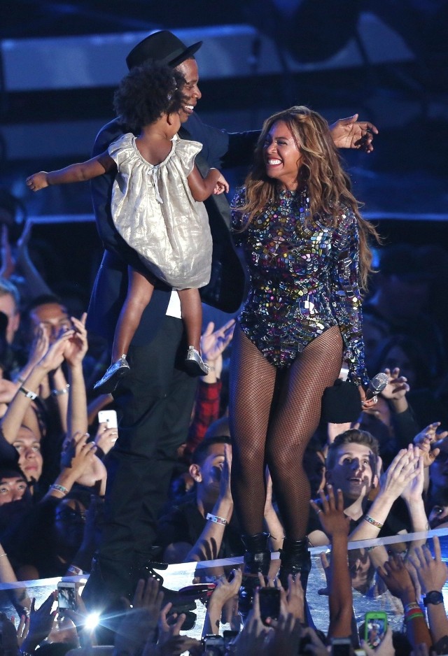 Beyonce (po prawej) akceptuje nagrodę Michael Jackson Video Vanguard Award za jej wkład artystyczny w kulturę podczas roznadnia nagrów MTV Video Music Awards. Na scenie towarzyszą jej mąż raper Jay-Z oraz ich córka Blue Ivy (24.08.2014, Inglewood, USA).