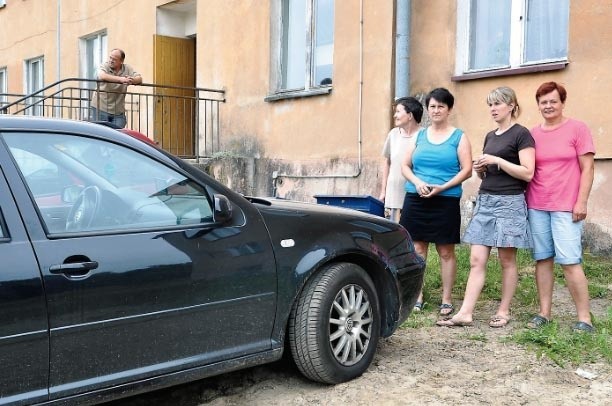 Lokatorzy bloku w Starym Chwalimiu wokół samochodu, który blokuje dostęp do zaworu z wodą. 