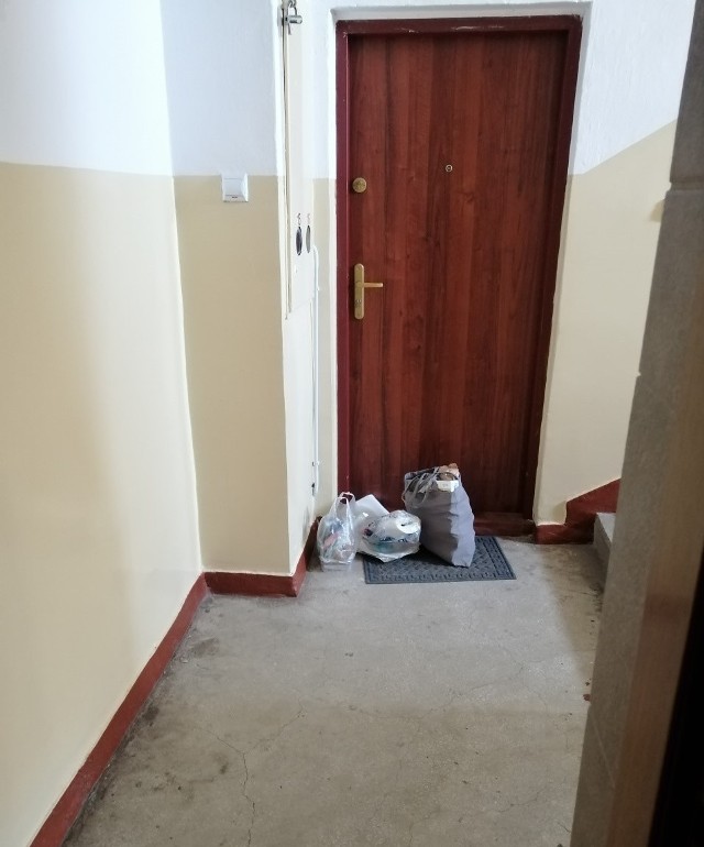 Przed drzwiami mieszkania, w którym przebywają pracownicy Danwoodu, rodziny zostawiają torby z jedzeniem