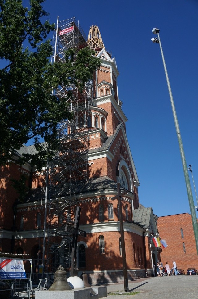 Stary krzyż i dzwony tworzą monument upamiętniający pożar.