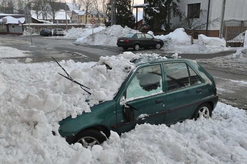 Zalegający na dachu śnieg spadł na zaparkowany pod nim samochód