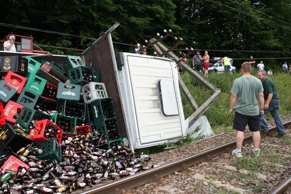 Rozpedzona ciezarówka iveco z trzema osobami przewrócila sie na tory przy dworcu w Biesowicach. Kierowca mial 2,5 promila alkoholu. Wiózl puste butelki po piwie.