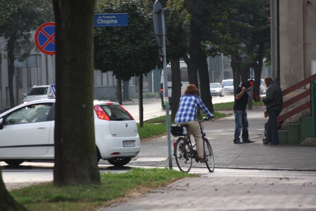 Rowerzystka zjeżdża ze ścieżki rowerowej na skrzyżowaniu z Chopina, jedzie przez pasy, a potem chodnikiem